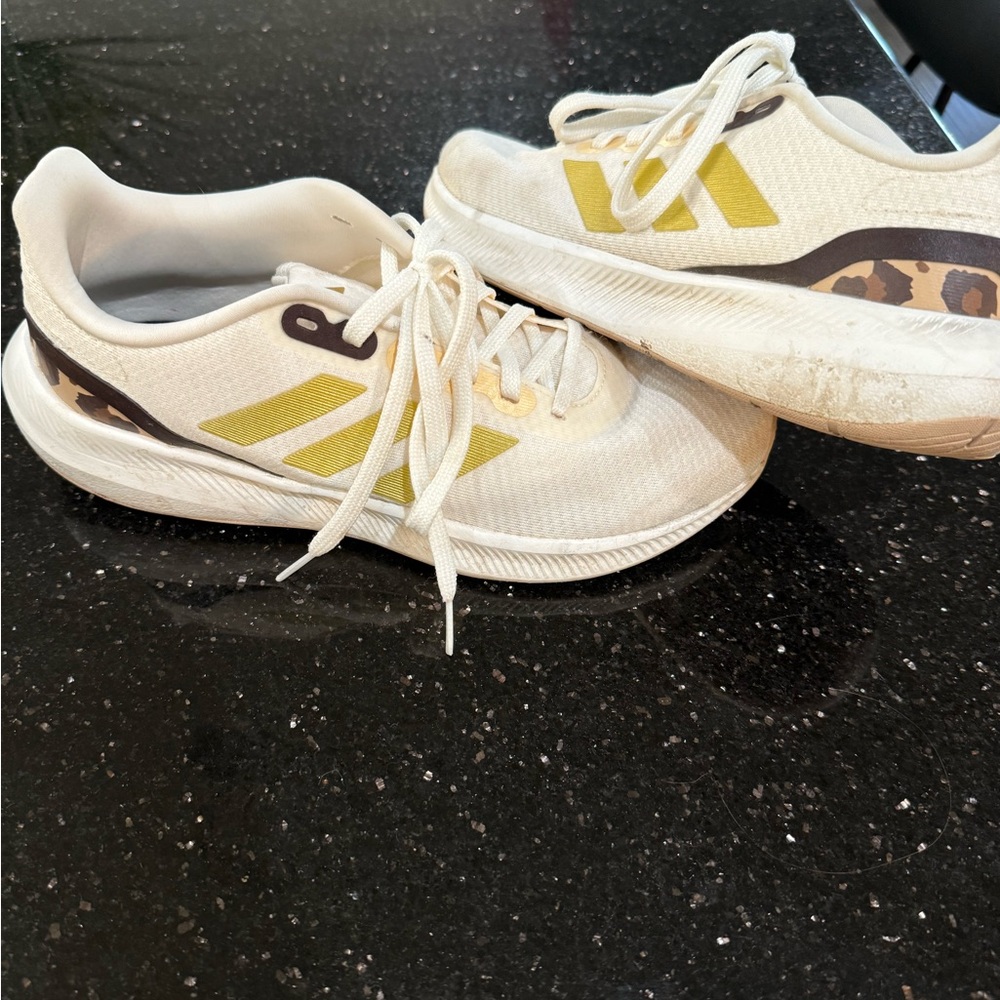 Adidas running shoes with gold and leopard accents